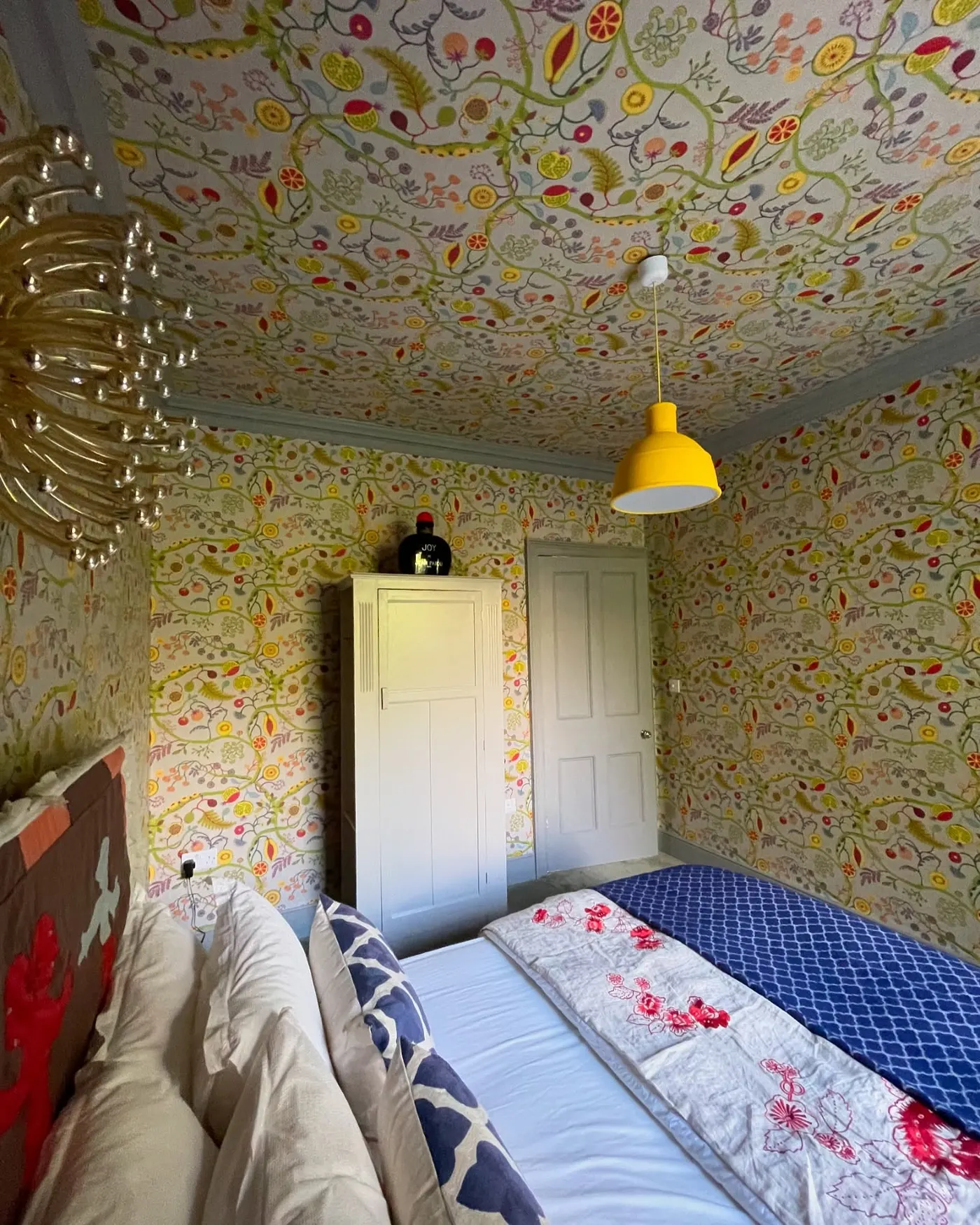 Colour-drenched room with golden patterned wallpaper