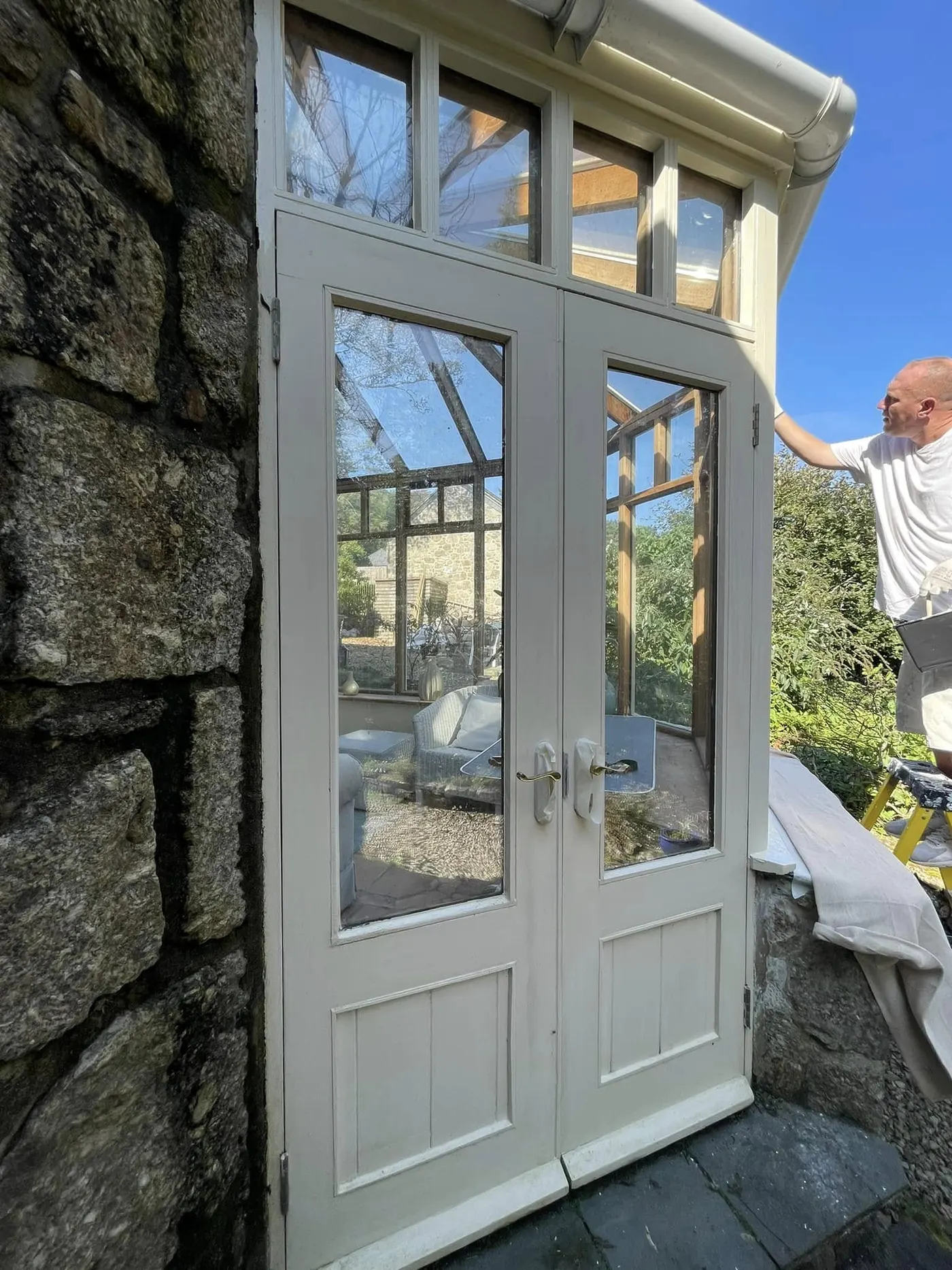 Repainted timber French doors set in granite