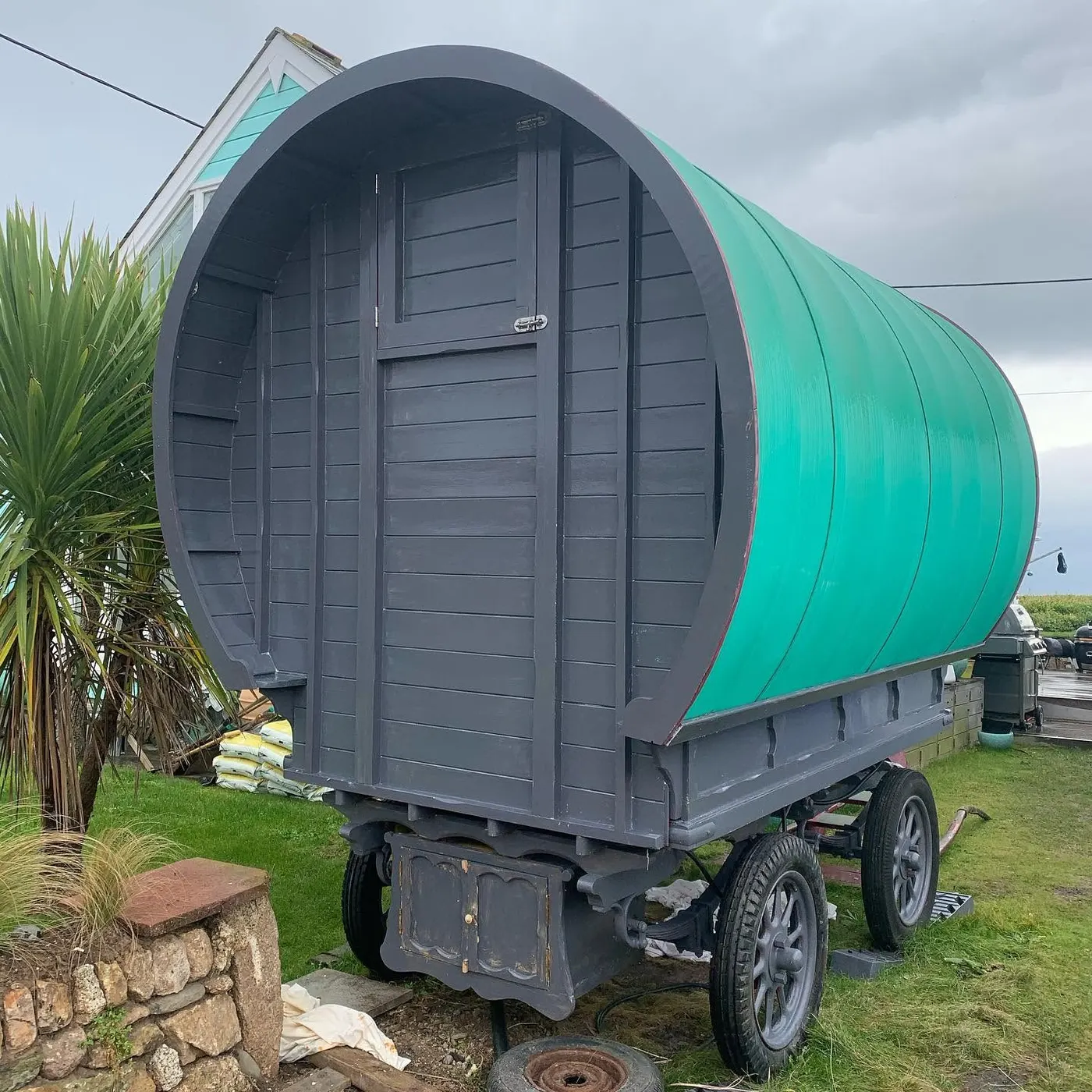 Shepherd's hut primed grey with a teal roof