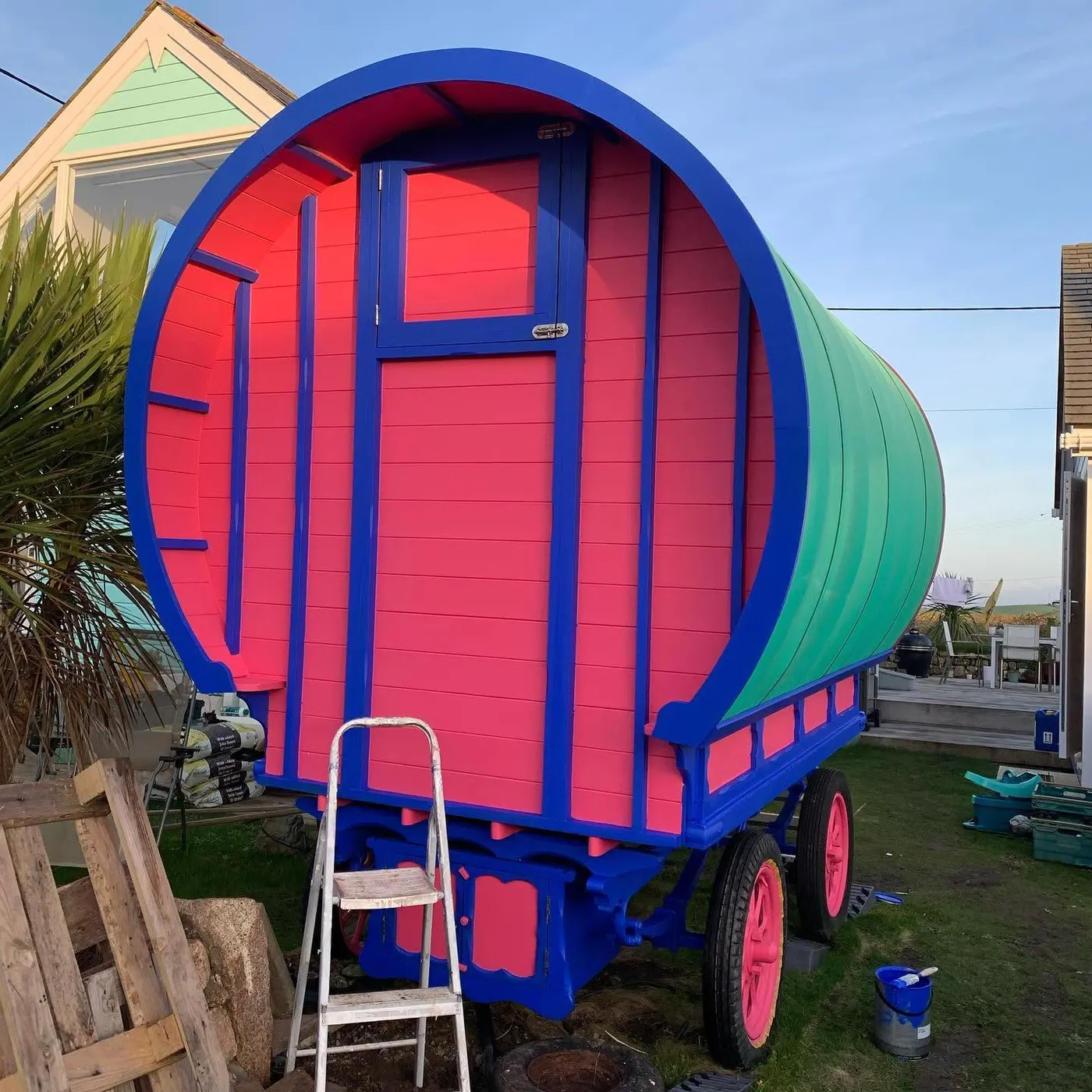 Shepherd's hut sprayed pink with blue trim