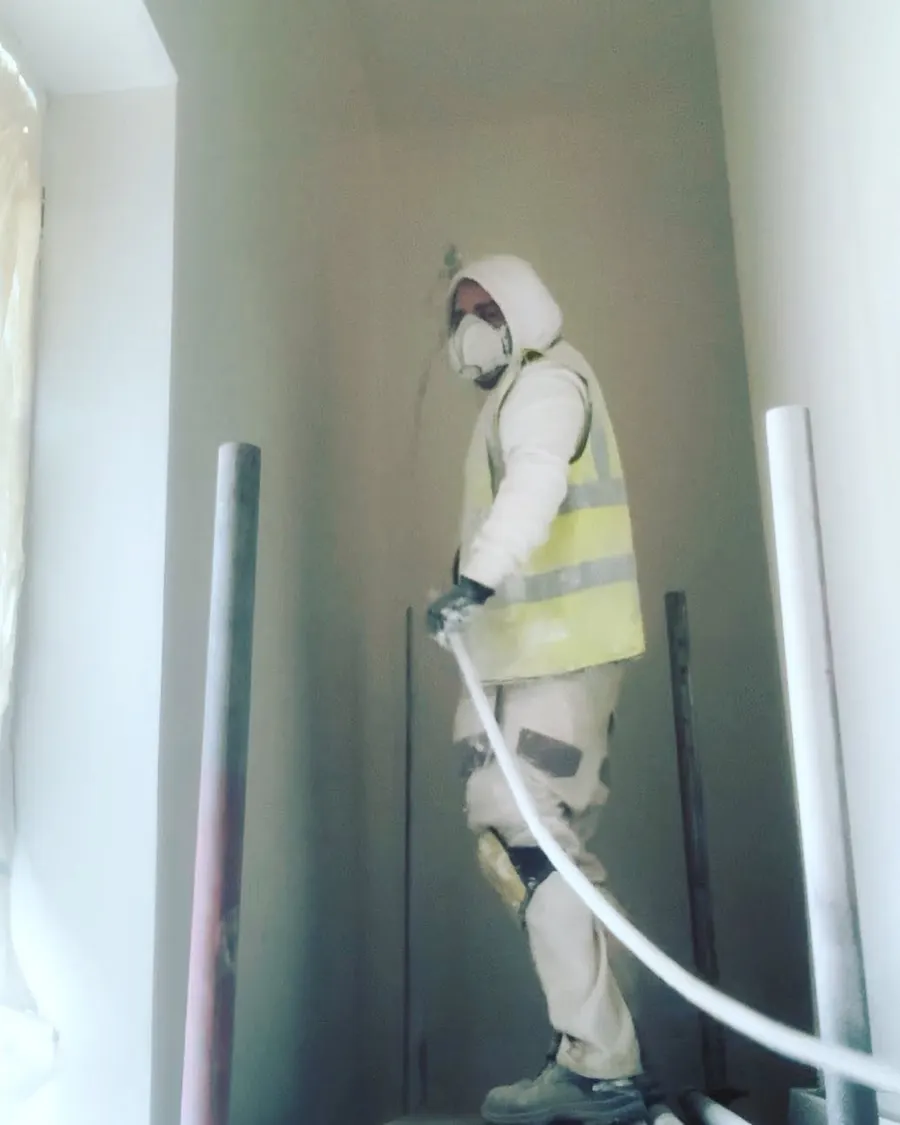 Decorator spray mist coating new plaster