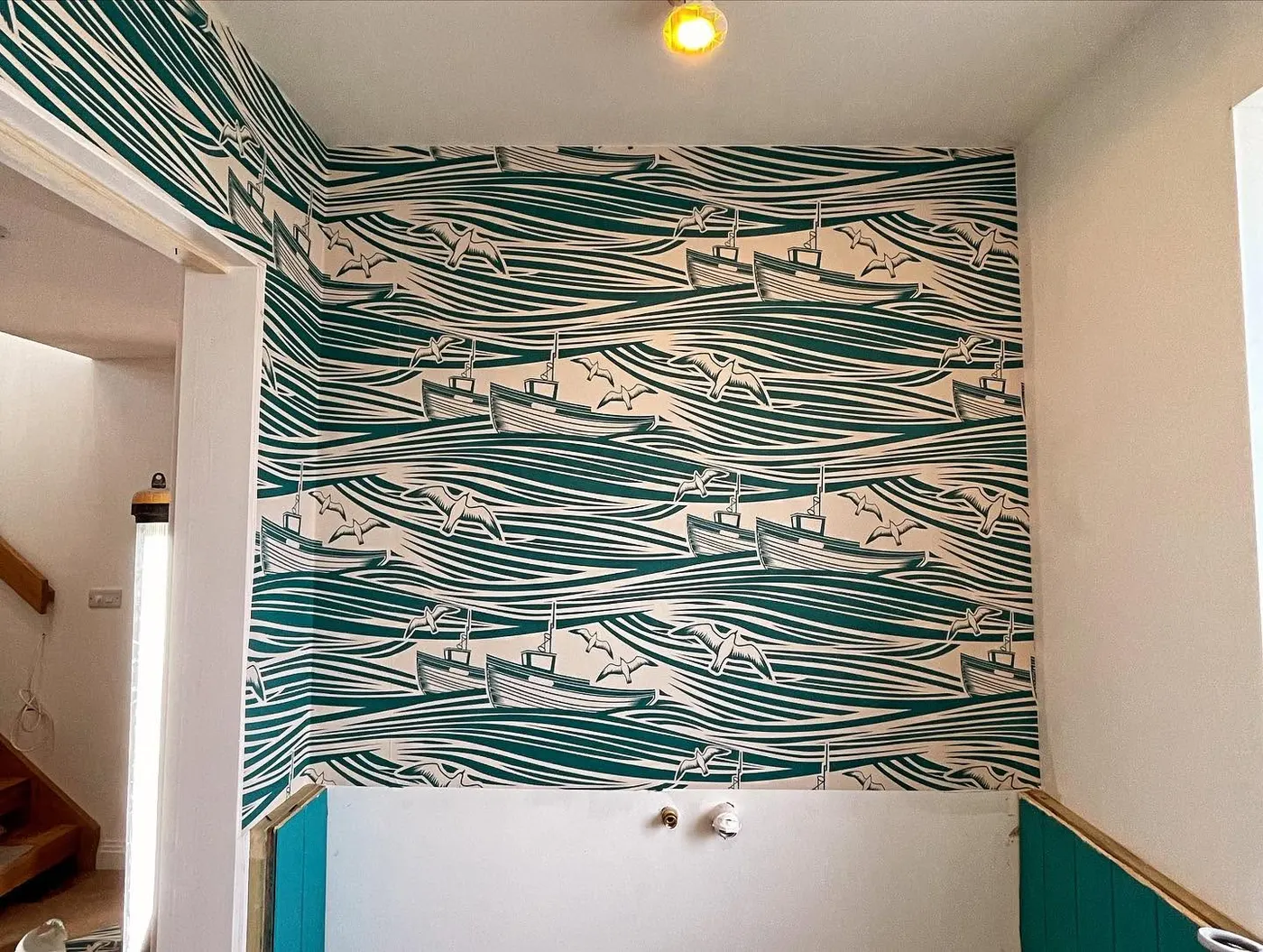 Stairwell hung with teal wave wallpaper