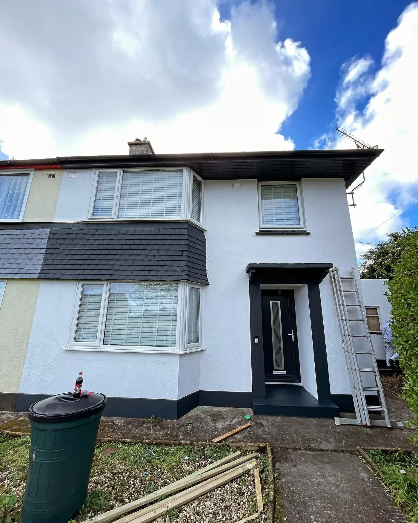 White pebbledash semi with dark slate-hung bay